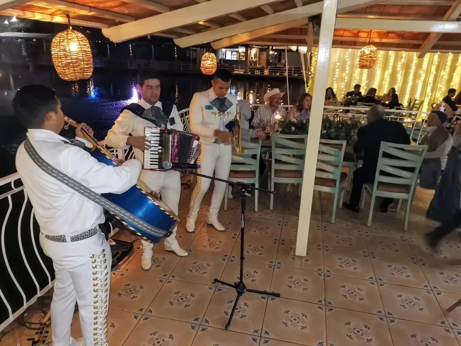 Mariachi Jalisco Es Tradición tocando en una terraza durante un evento nocturno